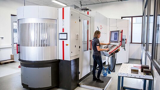 an overall view of the Hermle high-performance, 5-axis Hermle C 32 U CNC machining centre with a PW 250 pallet changer with storage; the PW 250 setup station is located at the front 
